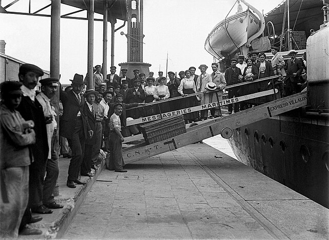 Historical photograph of immigrants departing a ship.